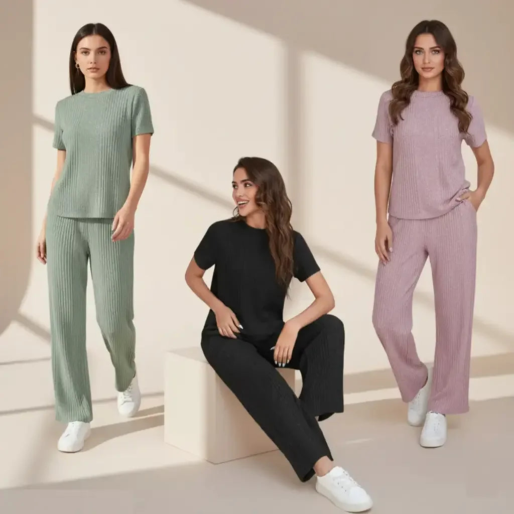 Three women wearing matching outfits in green, black, and pink on a neutral background.